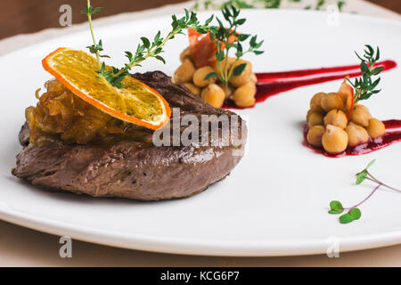 Juteux steak de boeuf avec sauce à l'orange avec les verts et les pois chiches Banque D'Images