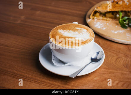 La tasse de Cappuccino et strudel aux pommes sur le fond de bois Banque D'Images