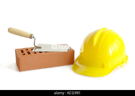 Brique perforée, truelle en acier inoxydable et jaune hard hat isolated on white Banque D'Images