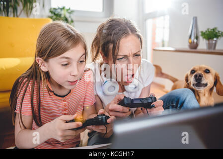 Mère et fille jouer à des jeux vidéo sur ordinateur portable à la maison Banque D'Images
