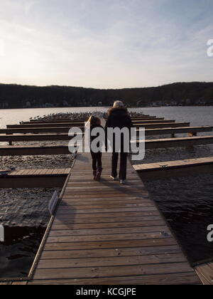 Lac Hopatcong, NJ en hiver, avec des nana et petite-fille marchant pendant un après-midi froid sur des quais vides dans une marina. Banque D'Images