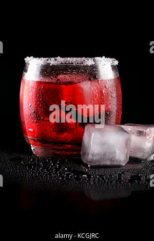 Froid de glace au citron vert cocktail rouge sur fond noir. Banque D'Images