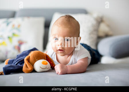 Adorable petit bébé garçon, Playing with toy, à la caméra à curieusement Banque D'Images