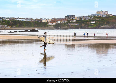 Surfeurs à Cornwall - surfeur traversant la plage de Great Western Beach à Newquay, en Cornwall. Banque D'Images