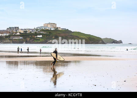 Surfeurs à Cornwall - surfeur traversant la plage de Great Western Beach à Newquay, en Cornwall. Banque D'Images