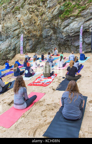 Un groupe de femmes pratiquant le yoga sur une plage - Surf Betty's Festival un festival tenu à Newquay et remise en forme l'autonomisation des femmes à travers le surf. Banque D'Images