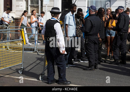 La recherche de la police, les fêtards s'arrêter et rechercher, au carnaval de Notting Hill, Londres, Angleterre, Royaume-Uni Banque D'Images