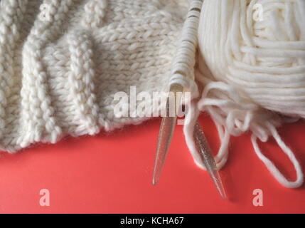 Fil de laine de mouton blanc dans un portable à la main en tricot tricot - un produit. passe-temps créatif. Banque D'Images