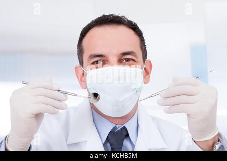 Portrait of male dentist holding miroirs inclinable et carver Banque D'Images