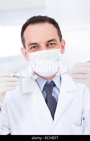 Portrait of male dentist holding miroirs inclinable et carver Banque D'Images