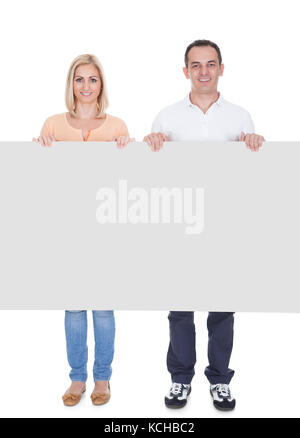 Heureux couple holding blank placard sur fond blanc Banque D'Images