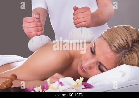 Belle Jeune femme Obtenir la thérapie de fines herbes à Spa Salon Banque D'Images