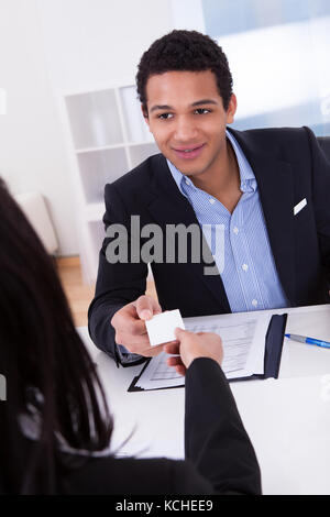 Portrait carte de visite offrant à man in office Banque D'Images