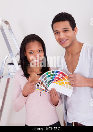 Portrait of African couple choosing colour for new home Banque D'Images