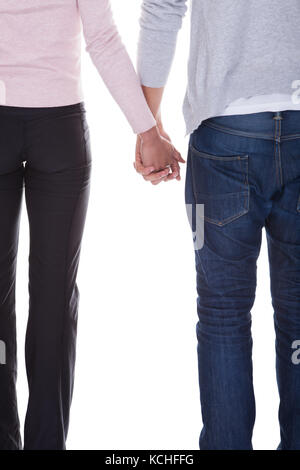 Young Couple Holding Hands Over White Background Banque D'Images
