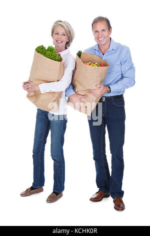 Happy senior couple légumes frais sur fond blanc Banque D'Images