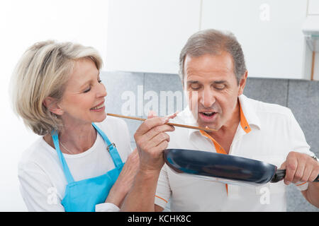 Homme recherche femme à la cuisson des aliments dans la cuisine Banque D'Images