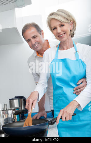 Homme recherche femme à la cuisson des aliments dans la cuisine Banque D'Images