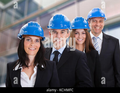 Portrait de Professionnels Architectes portant casque et Standing in a Row Banque D'Images