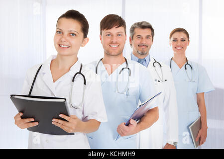 Portrait Of Happy Doctors Standing In Row Banque D'Images