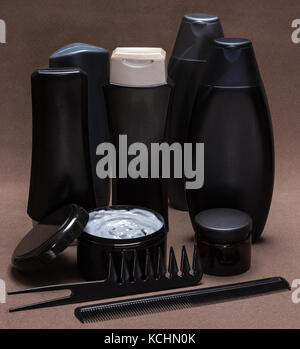 Soins des cheveux et produits coiffants et accessoires. noir et gris contenants cosmétiques, très large dent et peignes à dents fines sur la surface texturée brun Banque D'Images