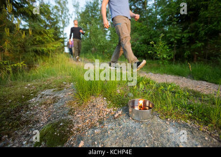 Hommes d'marche sur sentier éclairé par des bougies à réchaud en forêt durant la randonnée Banque D'Images