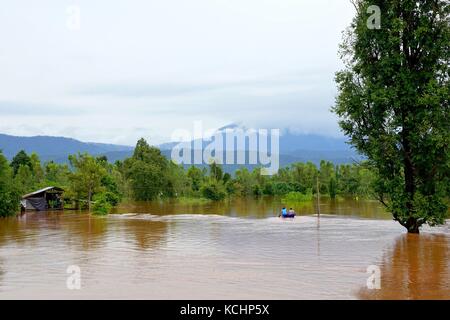 Halong, Vietnam- septembre 16,2017 : flash flood par red l'eau trouble, descend de la montagne en raison de pluies torrentielles avec des gens paddling boa Banque D'Images