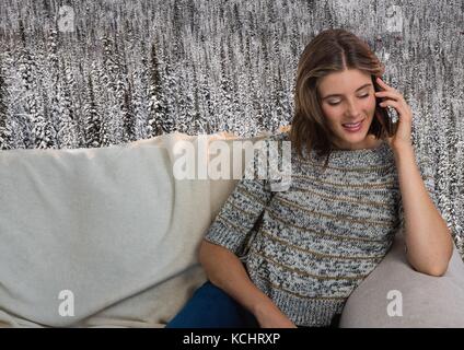 Digital composite of Woman avec cavalier sur téléphone sur table en face de la forêt de la neige Banque D'Images