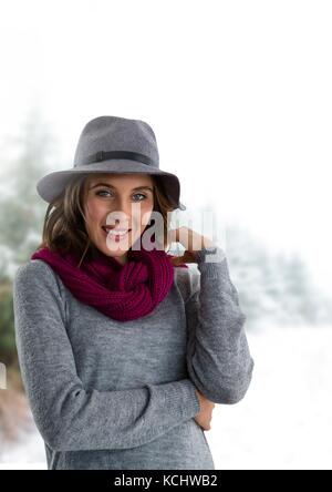 Digital composite of Woman wearing hat and scarf in snow forest Banque D'Images