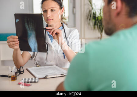 Médecin en expliquant la cheville de la jambe du patient à rayons X Banque D'Images