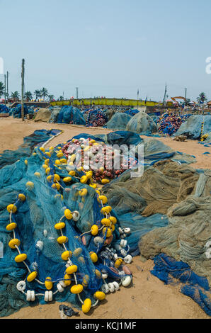 Filets de pêche jaune bleu avec les nageurs répartis sur le terrain au port d'Elmina, Ghana, Afrique de l'ouest Banque D'Images