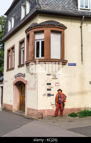 Une femme dans un chapeau à côté de l'eau élevée (Hochwasser) marqueurs d'inondation sur le mur de la maison, Neumagen-Dhron, vallée de la Moselle, Rheinland-Pfalz, Allemagne Banque D'Images