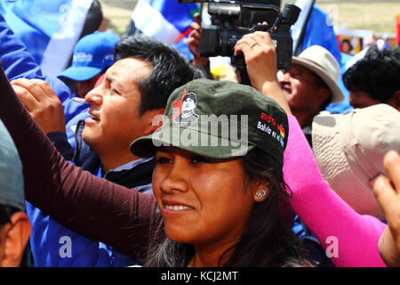 Jeune femme portant chapeau militaire avec Che Guevara portrait style du président bolivien Evo Morales à l'avant à un événement politique, Orinoca, Bolivie Banque D'Images