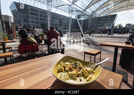 Munich, Allemagne - Septembre 21th, 2017 : une assiette de ravioli à la crème sur une table en bois à l'extérieur à l'aéroport Franz Joseph Strauss , Munich, germa Banque D'Images