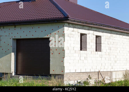 La construction et l'isolation avec de la mousse d'une petite maison. photo close up Banque D'Images