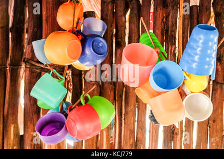 Verres en plastique multicolore accroché sur le mur de cabane en bois au Mexique Banque D'Images