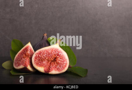 Tranches de figues fraîches mûres sur table en pierre Banque D'Images