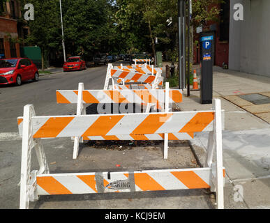 La sécurité de la construction bois transporteurs dans une orange blanc sur une rue de Brooklyn. Banque D'Images