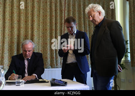 James Gray, député de North Wiltshire (à gauche) et Lincoln Seligman, filleul de Sir Edward Heath (à droite), regardent une déclaration de la police de Wiltshire sur un iPad avant une conférence de presse au Wrag Barn Golf & Country Club de Wiltshire. Banque D'Images