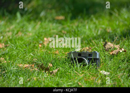 Old vintage analog photo télémètre appareil photo en fond d'herbe nature automne Banque D'Images