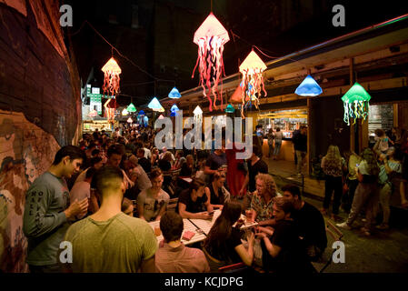 Scène de nuit typique dans la ruine Kuplung pub bar à Budapest avec les gens de boire assis debout parler .... Banque D'Images