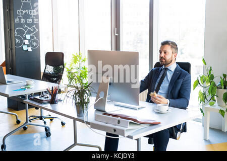 Businessman au bureau avec ordinateur dans son bureau. Banque D'Images