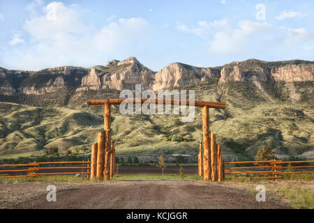 Un ranch en bois en face de la porte d'escarpements rocheux dans le Wyoming, USA Banque D'Images