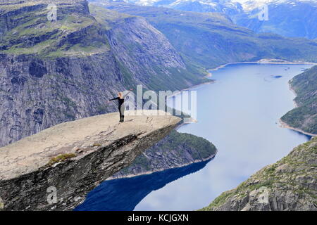 Randonneur femme posant et enjoying view à partir de Trolltunga rock formation en Norvège Banque D'Images