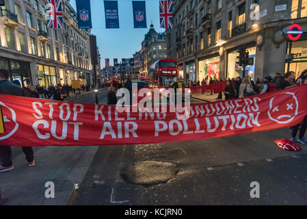 Londres, Royaume-Uni. 5 octobre 2017. Maintenez les militants de bloquer les bannières Oxford Circus. un des quartiers les plus fréquentés, les carrefours, dans une brève manifestation contre le niveau dangereux de la pollution de l'air à Londres, en expliquant aux automobilistes et piétons que le NO2 et les particules de fumées trafic conduisent à des milliers de décès prématurés chaque année à Londres ainsi que la souffrance chronique beaucoup de maladies pulmonaires et des problèmes respiratoires. Crédit : Peter Marshall/Alamy Live News Banque D'Images