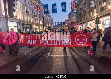 Londres, Royaume-Uni. 5 octobre 2017. Maintenez les militants de bloquer les bannières Oxford Circus. un des quartiers les plus fréquentés, les carrefours, dans une brève manifestation contre le niveau dangereux de la pollution de l'air à Londres, en expliquant aux automobilistes et piétons que le NO2 et les particules de fumées trafic conduisent à des milliers de décès prématurés chaque année à Londres ainsi que la souffrance chronique beaucoup de maladies pulmonaires et des problèmes respiratoires. Crédit : Peter Marshall/Alamy Live News Banque D'Images