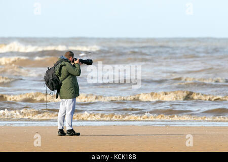 Observation des oiseaux, ornithologie, ornithologues, jumelles d'observation de la faune, lunettes, optiques, trépieds dans la réserve naturelle de Southport Merseyside, PHOTOGRAPHE chassent les oiseaux sauvages, oiseaux aquatiques et oiseaux de mer, tandis que de beaux rayons de soleil d'automne chauds se laissent tomber sur les sables dorés de la plage de Southport à Merseyside. Banque D'Images