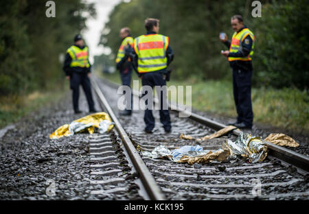 Ochtrup, Allemagne. 6 octobre 2017. Des policiers se tiennent sur la voie ferrée près d'Ochtrup, Allemagne, le 6 octobre 2017. Près de Gronau, dans la région de Muensterland, des activistes ont bloqué une voie ferrée pendant plus de onze heures. Ils voulaient arrêter un train atteignant l'usine de traitement de l'uranium de Gronau. La route a été fermée jusqu'aux premières heures du matin. Crédit : Guido Kirchner/dpa/Alamy Live News Banque D'Images