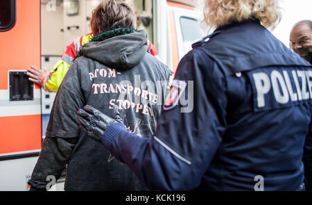 Ochtrup, Allemagne. 6th octobre 2017. Un activiste s'opposant à l'enegry nucléaire est escorté vers une voiture d'ambulance par un policier près d'Ochtrup, Allemagne, le 6 octobre 2017. Près de Gronau, dans la région de Muensterland, des militants ont blocked une voie ferrée pendant plus de onze heures. Ils voulaient arrêter un train pour atteindre l'usine de traitement de l'uranium de Gronau. L'itinéraire a été fermé jusqu'aux premières heures du matin. Credit: Guido Kirchner/dpa/Alay Live News Banque D'Images