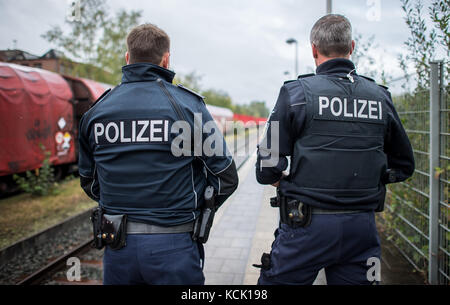 Ochtrup, Allemagne. 6 octobre 2017. Des policiers se tiennent debout sur la plaque du commissariat à Ochtrup, Allemagne, le 6 octobre 2017. Un train avec des déchets radioactifs roule par. Près de Gronau, dans la région de Muensterland, des activistes ont bloqué une voie ferrée pendant plus de onze heures. Ils voulaient arrêter un train atteignant l'usine de traitement de l'uranium de Gronau. La route a été fermée jusqu'aux premières heures du matin. Crédit : Guido Kirchner/dpa/Alamy Live News Banque D'Images